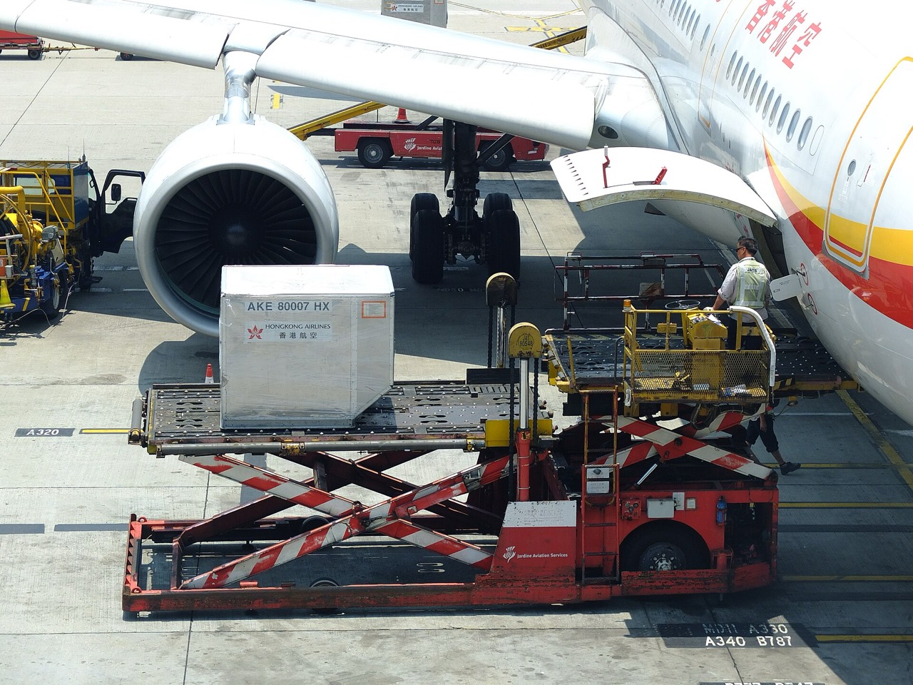 Cargo loader raising a unit load device to an aircraft hold